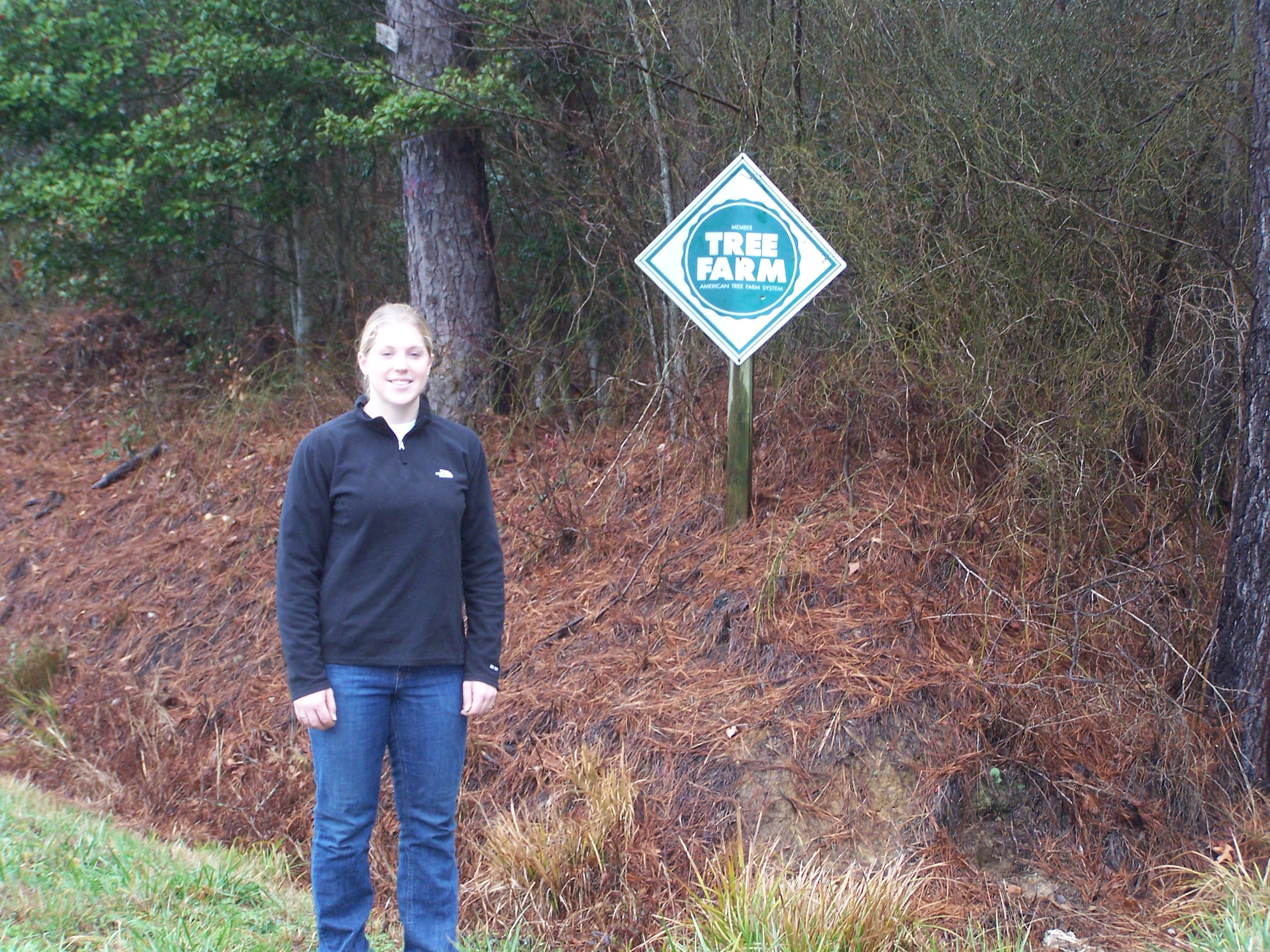 The Culp family in front of their Tree Farm sign